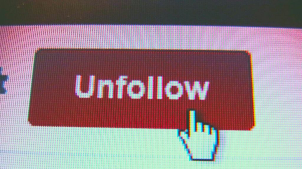 Un botón digital "Unfollow", a menudo utilizado en plataformas de redes sociales para dejar de seguir a un usuario o página.